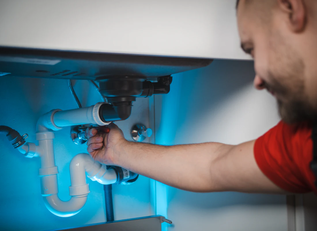 Licensed {{CITY}} plumber from {{BUSINESS_NAME}} repairing pipes on a residential job